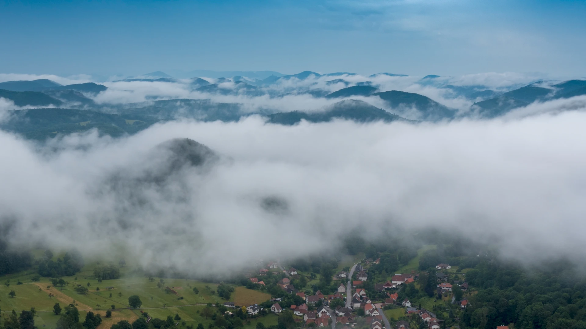 Luftaufnahme von Bergen und Wolken mit Drohne – professioneller Drohnenpilot und Luftbildservice von Müller Filmt aus Berlin