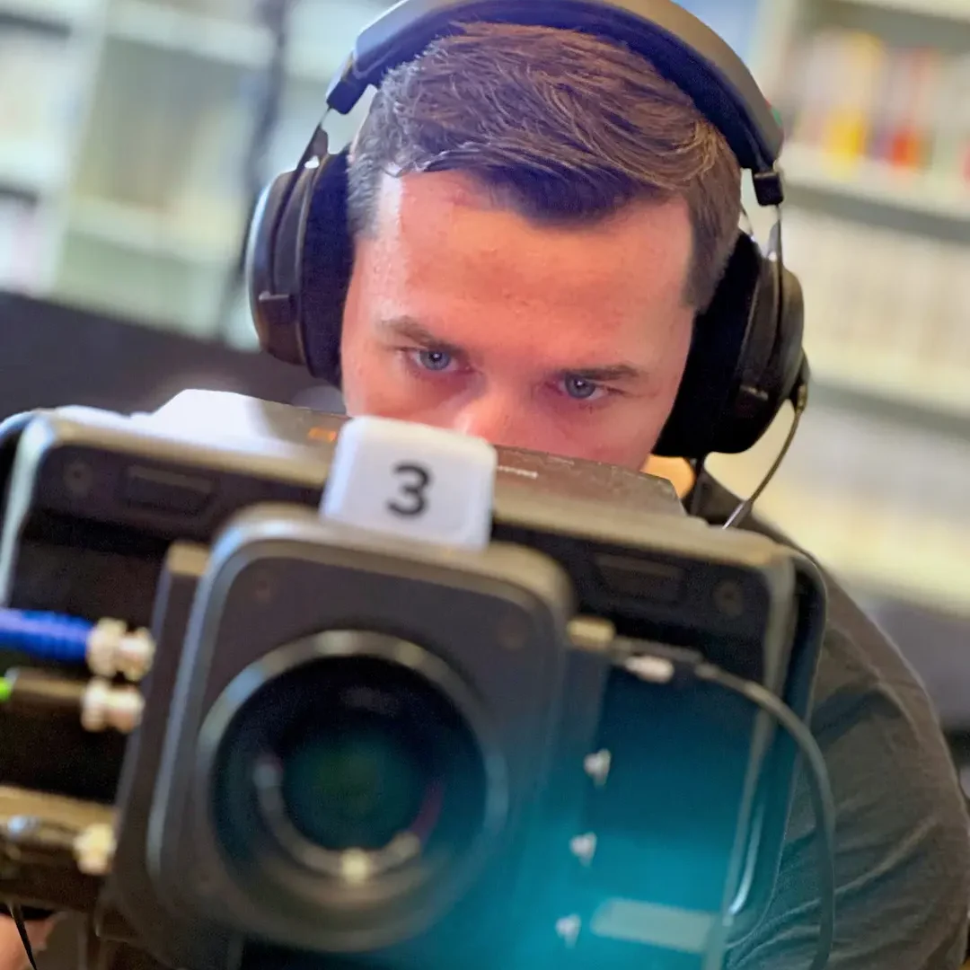 Videograf Armin Müller an einer Studiokamera mit Intercom für Livestreams in einem Büro
