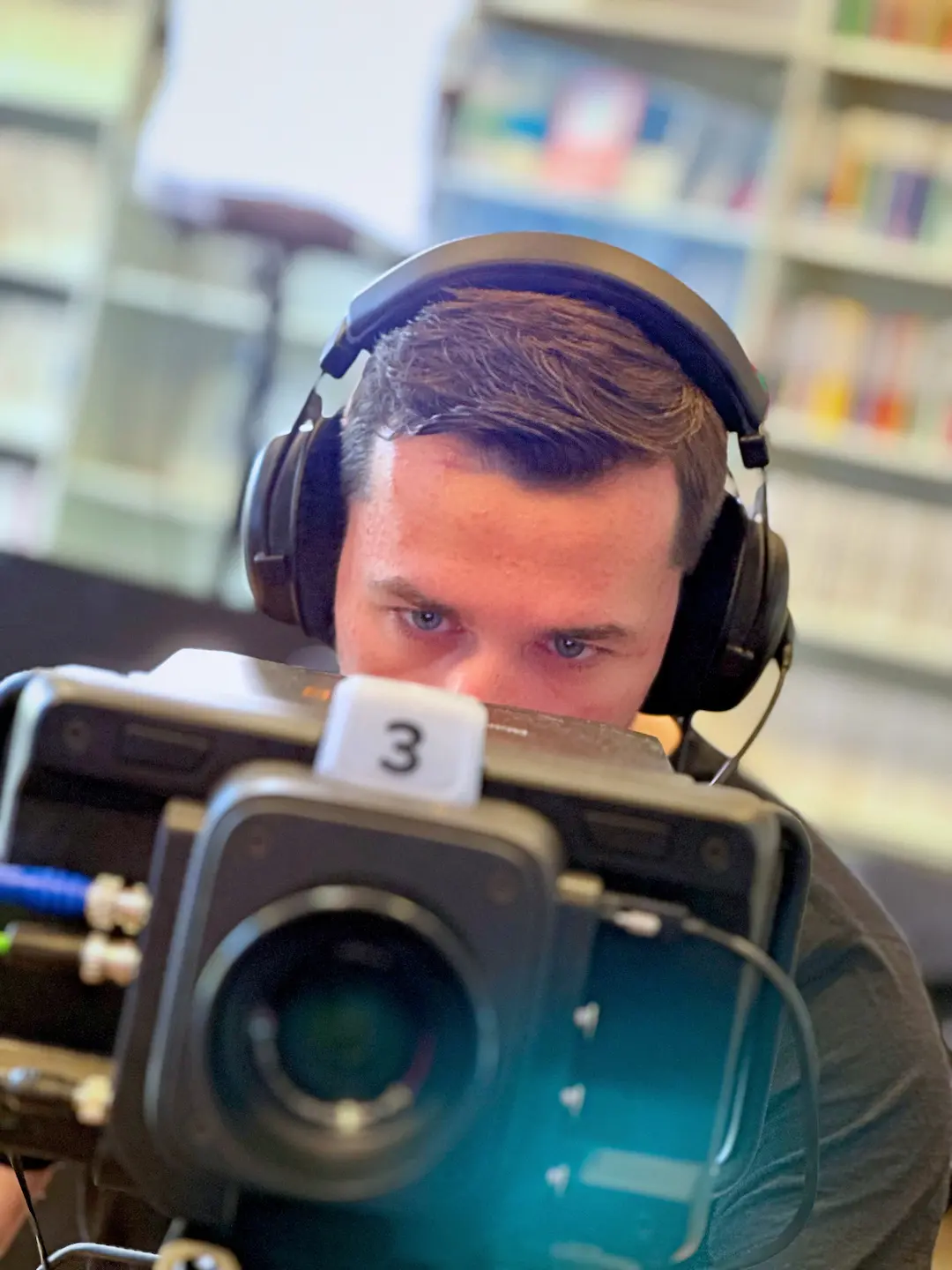 Videograf Armin Müller an einer Studiokamera mit Intercom für Livestreams in einem Büro